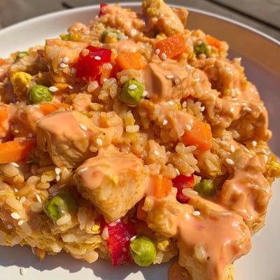 This Bang Bang Fried Rice features fluffy jasmine rice, crisp bell peppers, and carrots stirred with scrambled eggs, served hot in a skillet.