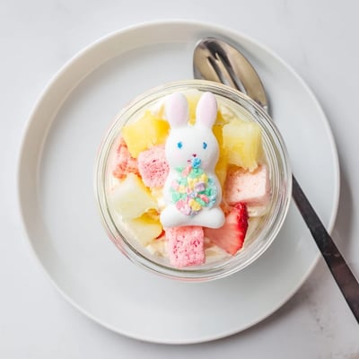A single Jello Pie Easter Bunny Parfait in a clear jar showcases creamy layers, diced strawberries, and bright pastel sprinkles.