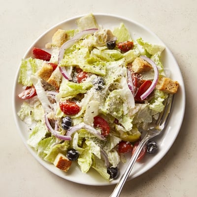 Fresh Olive Garden Salad in a bowl with crunchy croutons and shaved Parmesan